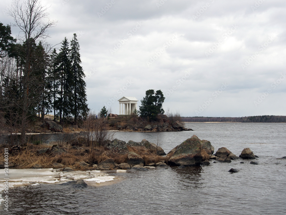 Northern landscape, rocky shores with sparse vegetation against the background of the sea with remnants of ice. Landscape photography, variety of landscapes, travel.