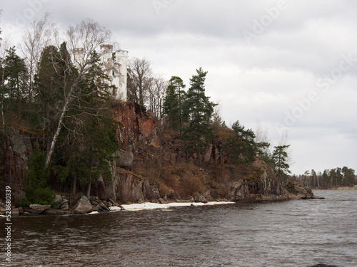 Northern landscape, rocky shores with sparse vegetation against the background of the sea with remnants of ice. Landscape photography, variety of landscapes, travel.