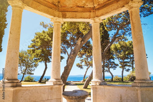 Coastal summer cityscape - view of the sea view from the gazebo with stone columns, park on the seashore in the city of Split, the Adriatic coast of Croatia photo