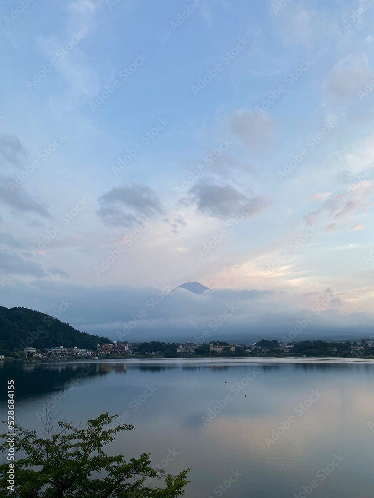 6pm, tip of Mt. Fuji’s head started to peak behind the thick clouds, showing us bless and saying hello after days of cloudy weeks.  We were lucky. Year 2022 August 26th, Yamanashi Kawaguchiko Lake.