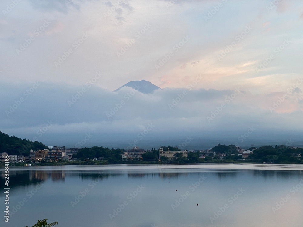 6pm, tip of Mt. Fuji’s head started to peak behind the thick clouds, showing us bless and saying hello after days of cloudy weeks.  We were lucky. Year 2022 August 26th, Yamanashi Kawaguchiko Lake.