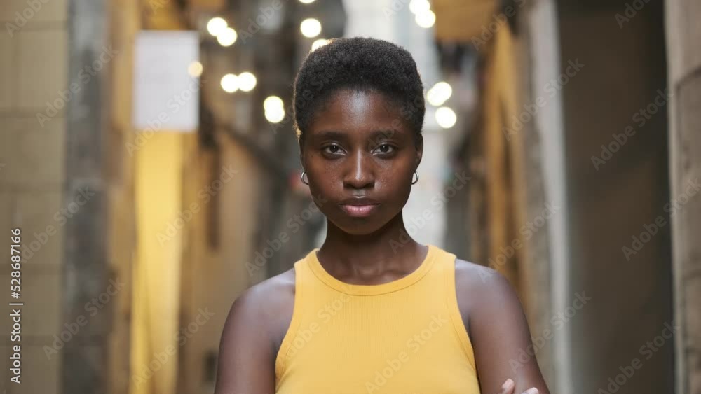 Young woman looking at the camera and smiling while standing on the street. Young woman looking at the camera and smiling while standing on the street.