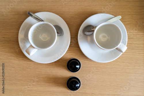 Couple cups in saucers with coffee capsules