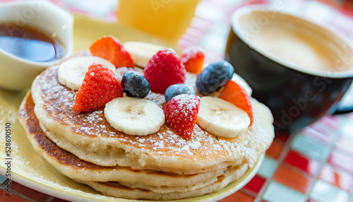 Belgian pancakes served with fruits and maple syrup