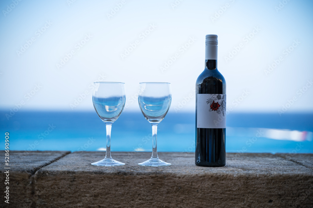 Wine and two glasses on the background of the sea on the balcony Wine and two glasses on the background of the sea on the balcony