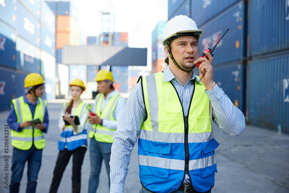 factory worker or engineer using walkie talkie and talking about work in containers warehouse storage factory worker or engineer using walkie talkie and talking about work in containers warehouse storage