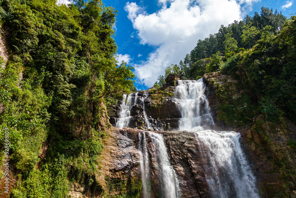 Grandiose unusually beautiful waterfall in the green jungle of the island of Sri Lanka. Photographed at close range