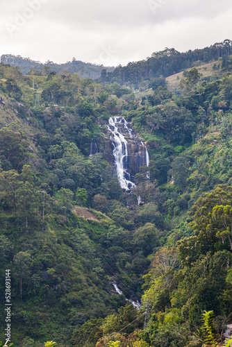 Obraz na płótnie Grandiose unusually beautiful waterfall in the green jungle of the island of Sri Lanka. Overall plan. Ella. Vertical frame w salonie