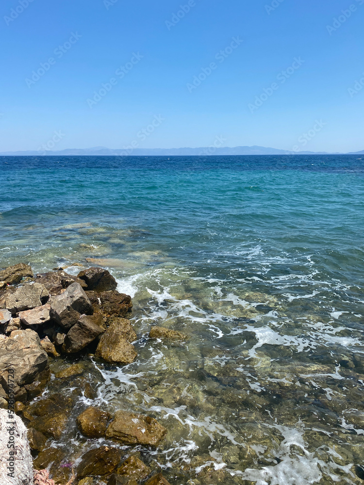 Beautiful view of the rocky beach and the skyline, blue water in the sea and clear sky Beautiful view of the rocky beach and the skyline, blue water in the sea and clear sky