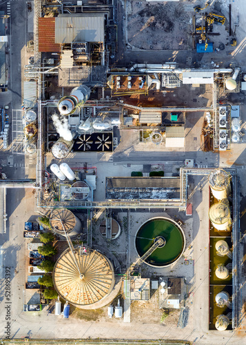 Bird's eye shot with drone, FIS chemical plant Gambellara (VI) Italy, September 05 2022 in the late afternoon. We see the production plants, liquid transport system and storage pipes, evaporative towe