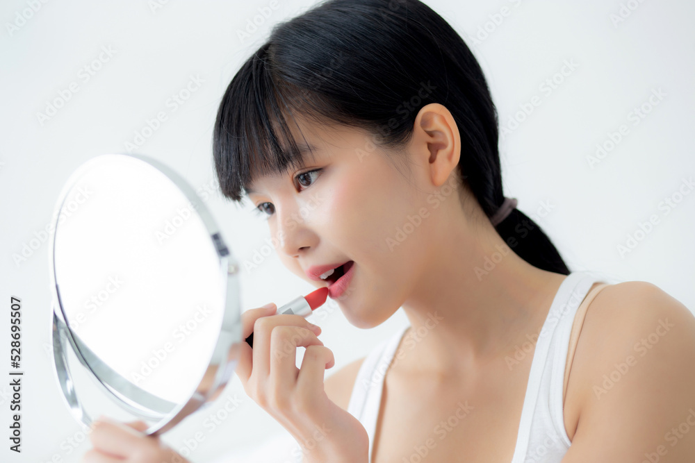 Beautiful young asian woman applying lipstick red on mouth, beauty girl looking facial at mirror for makeup cosmetic with lips elegance, make up with sexy of female, skin care and health concept. Beautiful young asian woman applying lipstick red on mouth, beauty girl looking facial at mirror for makeup cosmetic with lips elegance, make up with sexy of female, skin care and health concept.