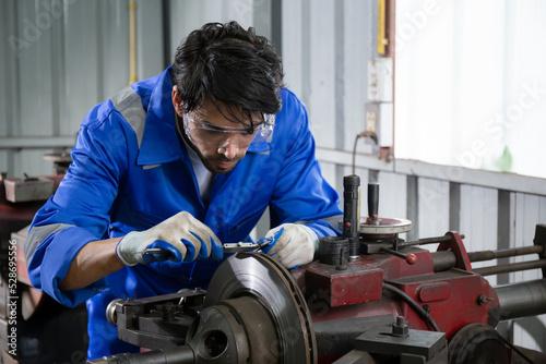 Young man sanding or iron at industrial factory, mechanic working job while polish metal, male having skill built steel with tool, engineer and equipment, labor and steelworks, industry concept.