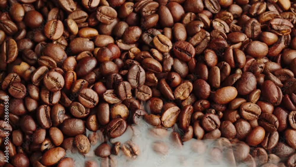 Roasting coffee beans with smoke on dark background, close up arabica robusta colombian beans. Roasting coffee beans with smoke on dark background, close up arabica robusta colombian beans.