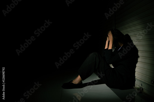 Fotografia Woman depressed from sad stress pain despair problem, person sit on closed shop on corridor alone with emotion lonely desperate upset head down