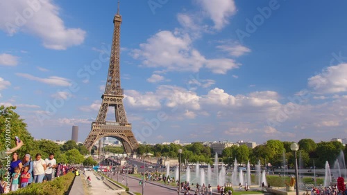 Timelapse, movement of clouds. People walk in Paris with the Eiffel Tower in the background. The most popular tourist attraction in the world. Paris, France photo