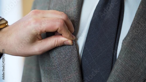 Tailor squeezing crease-resistant tweed suit jacket lapel, close up. photo