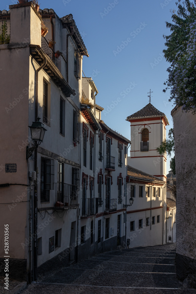 Typical white streets in the historic neighborhood of Albaicin in the city of Granada at sunset. Andalucia, Spain.