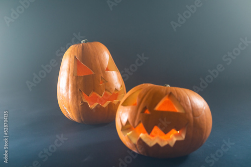 Close up view of two carved halloween pumpkin against black background