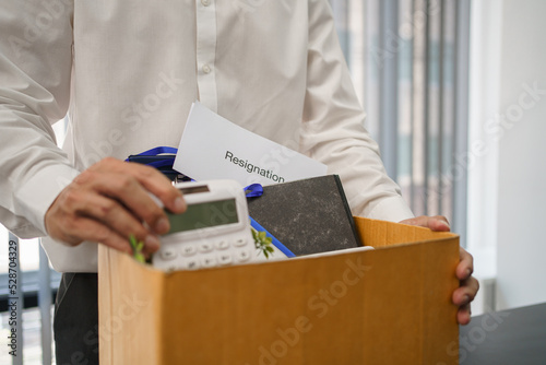 Resignation concept, Male employee packing personal belonging and resignation letter in the box