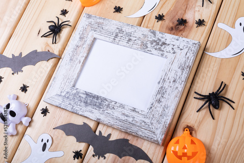 Frame with copy space and multiple halloween toys on wooden surface
