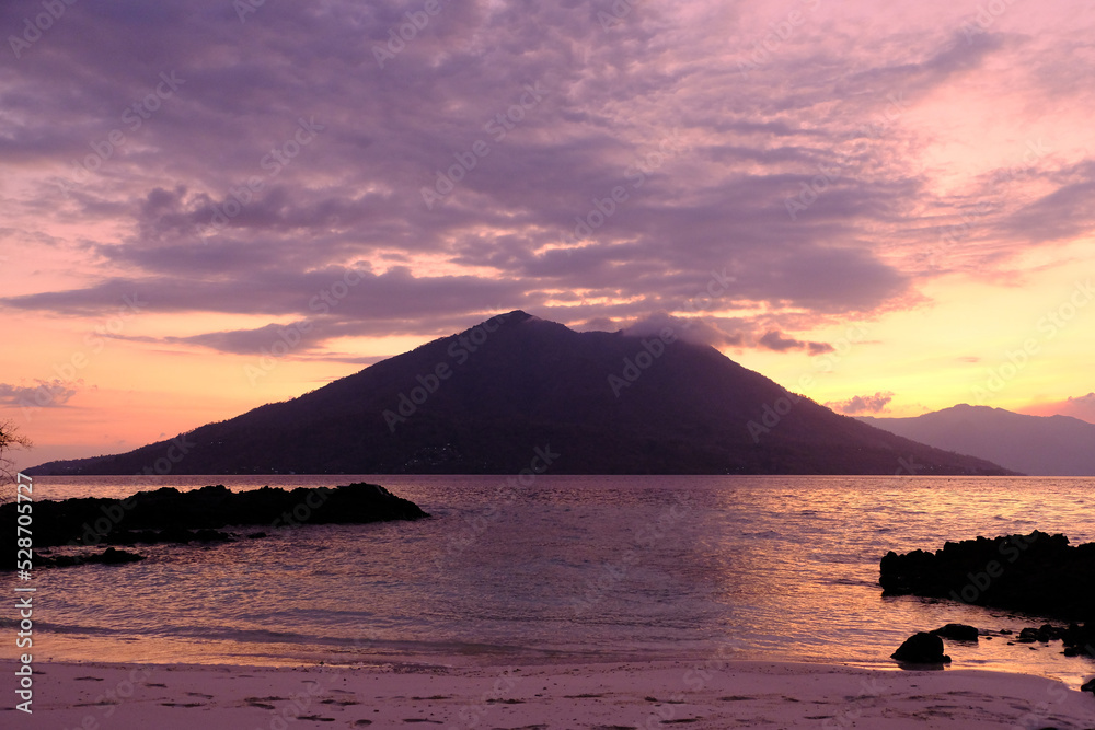 Indonesia Alor Island - Rocky beach and vulcano at sunset