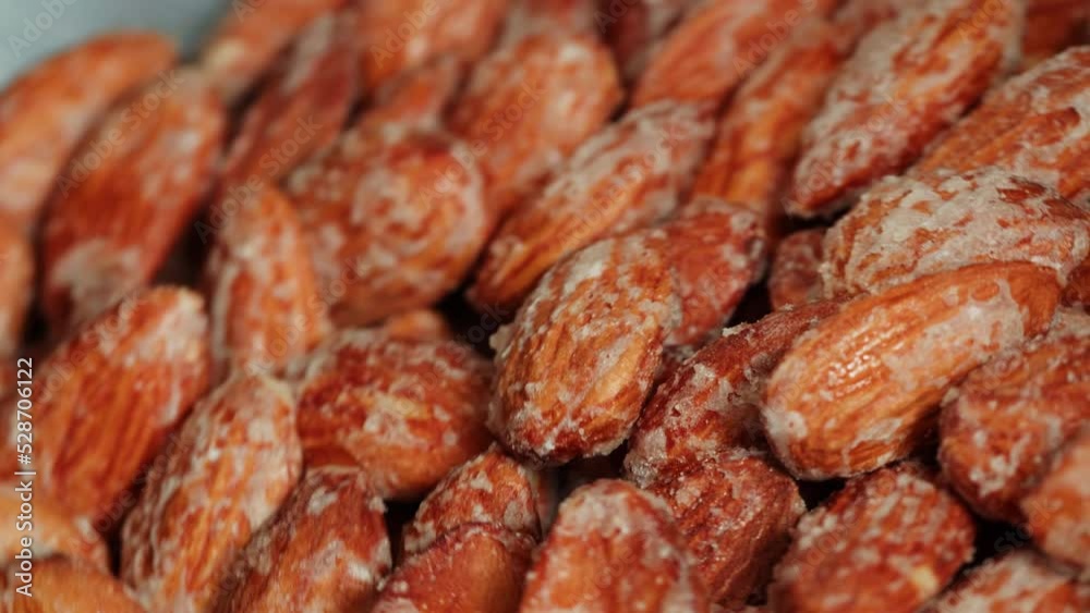 Fried almond in sugar, production of sugared nuts. Factory of healthy sweet food. Cooking dessert snack close-up. Fried almond in sugar, production of sugared nuts. Factory of healthy sweet food. Cooking dessert snack close-up.