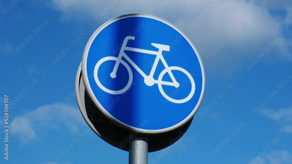 Round road sign depicting white bicycle on blue background, meaning