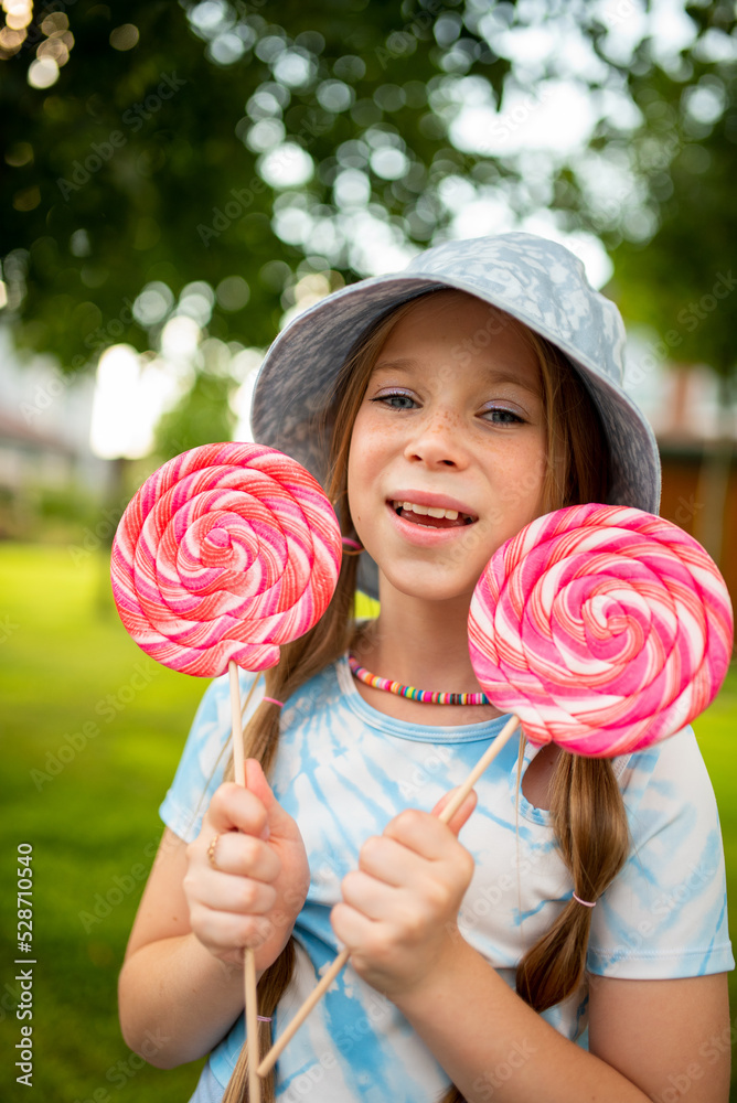 the child eats a bright lollipop. Beautiful girl model eats a bright