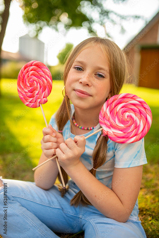 the child eats a bright lollipop. Beautiful girl model eats a bright