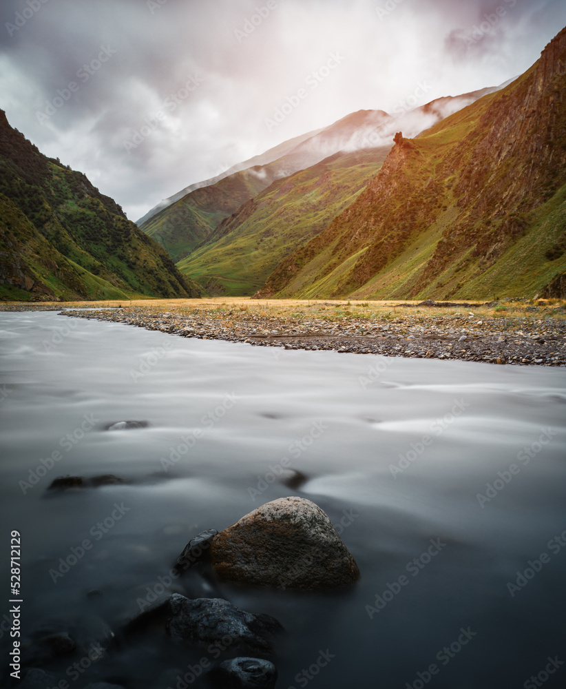 River in mountains near Stepantsminda, Georgia. Long exposure and lens flare effects.