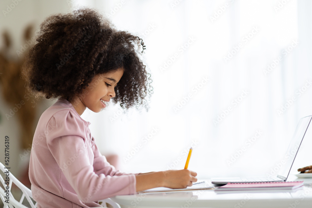 SIde view of adorable little black girl doing homework SIde view of adorable little black girl doing homework
