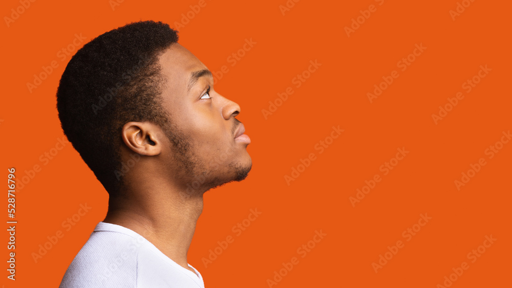 Side View Of Serious Black Guy Posing Over Orange Background Side View Of Serious Black Guy Posing Over Orange Background