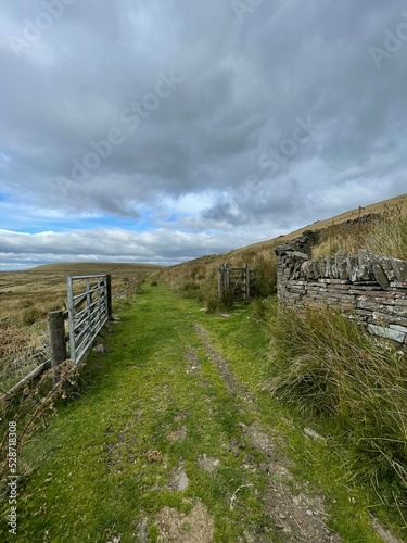 Dry stone wall in rural farmland with no people and a dramatic sky background. 