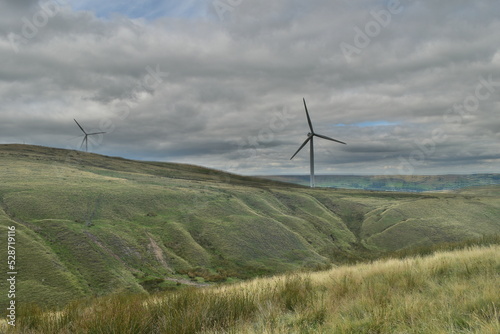 Wind turbines in the countryside with a cloudy sky background. 