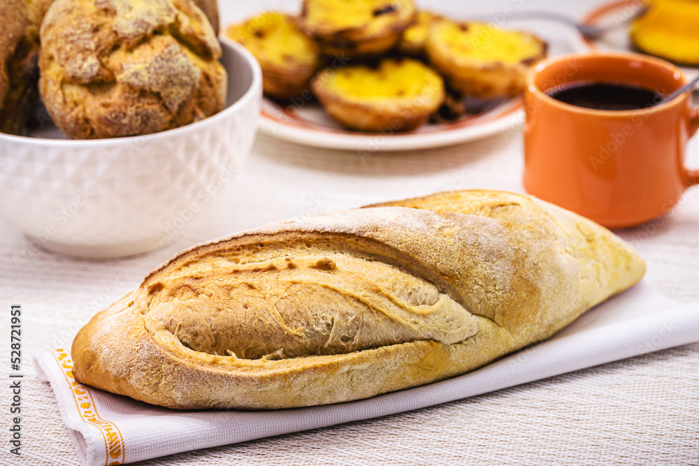 Portuguese bread, called cacete, served for breakfast with bread and typical sweets, european breakfast Portuguese bread, called cacete, served for breakfast with bread and typical sweets, european breakfast