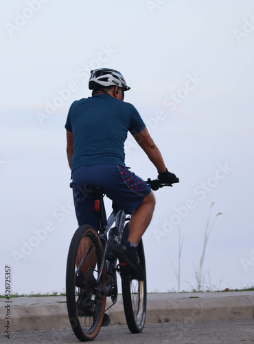 person riding a bicycle, rear view