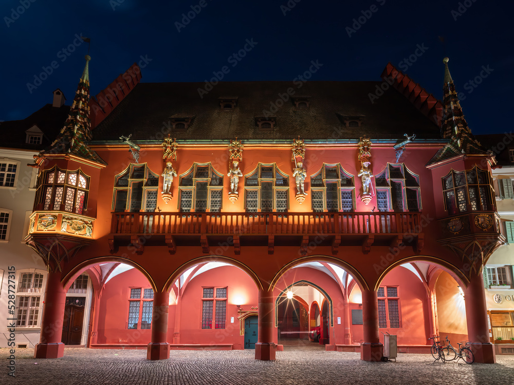 Fototapeta premium Freiburg im Breisgau - April 13, 2022: Historic department store in blue hour - important 14th-century Gothic building with large halls and courtyard for events.