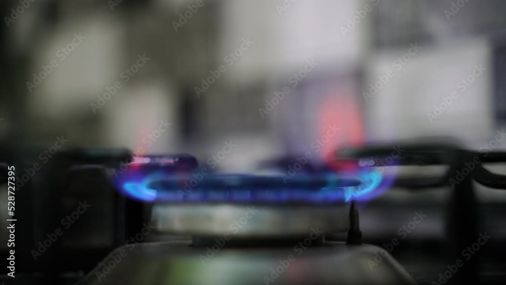 Kitchen burner turning on. Stove top burner igniting into a blue cooking flame. Kitchen burner turning on. Stove top burner igniting into a blue cooking flame.