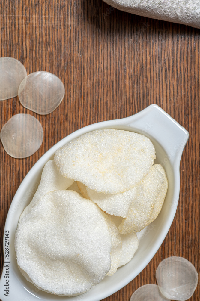 Crispy prawn crackers, deep fried, are served in an oval dish as a starter. Top view. Crispy prawn crackers, deep fried, are served in an oval dish as a starter. Top view.