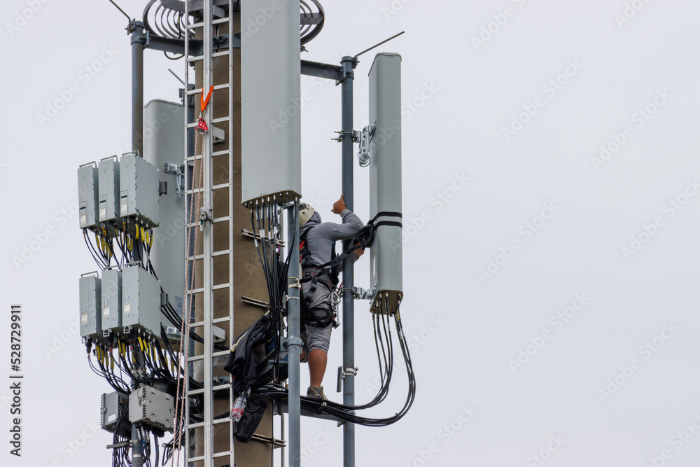 Naklejka premium Telekom technicians perform work on a transmission tower