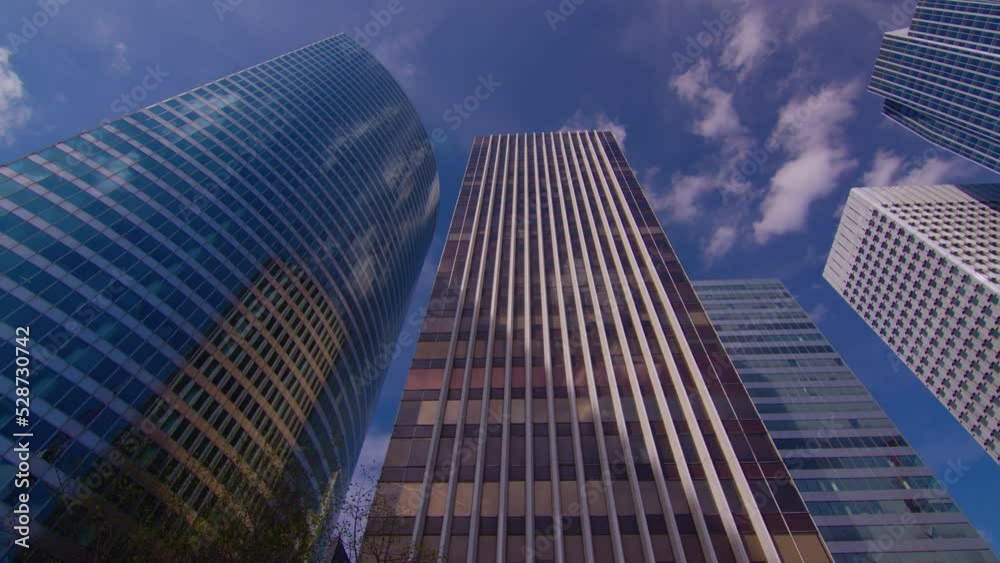 Timelapse. Skyscrapers modern business and financial district in Paris with high rise buildings and convention center. Blue cloudy sky in summer day. Reflections Timelapse. Skyscrapers modern business and financial district in Paris with high rise buildings and convention center. Blue cloudy sky in summer day. Reflections
