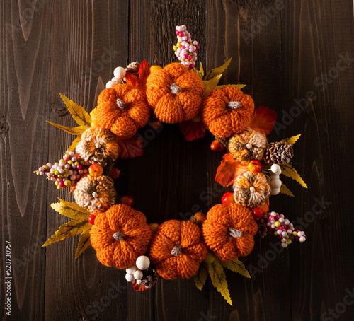 Autumn decoration for the house in the form of a wreath of knitted pumpkins. Handmade, autumn concept, Thanksgiving