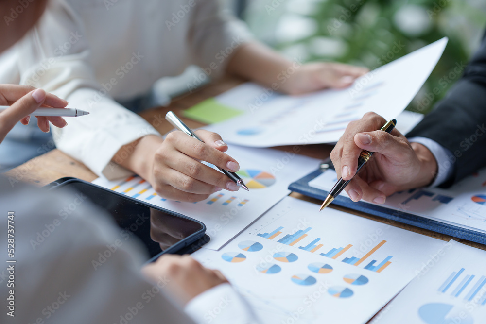 Business people gather for a brainstorming meeting pointing to a graph to think about market data analysis. New product plan new marketing and sales strategy to expand existing branche.. - obrazy, fototapety, plakaty 