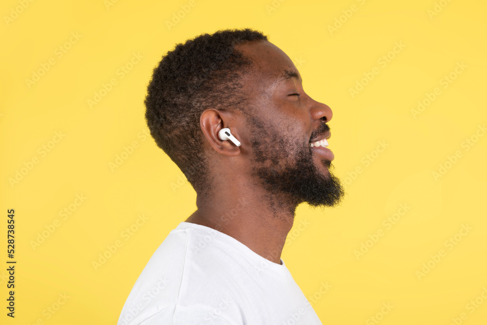 Fototapeta premium Happy African Man Listening Music Wearing Earbuds Over Yellow Background