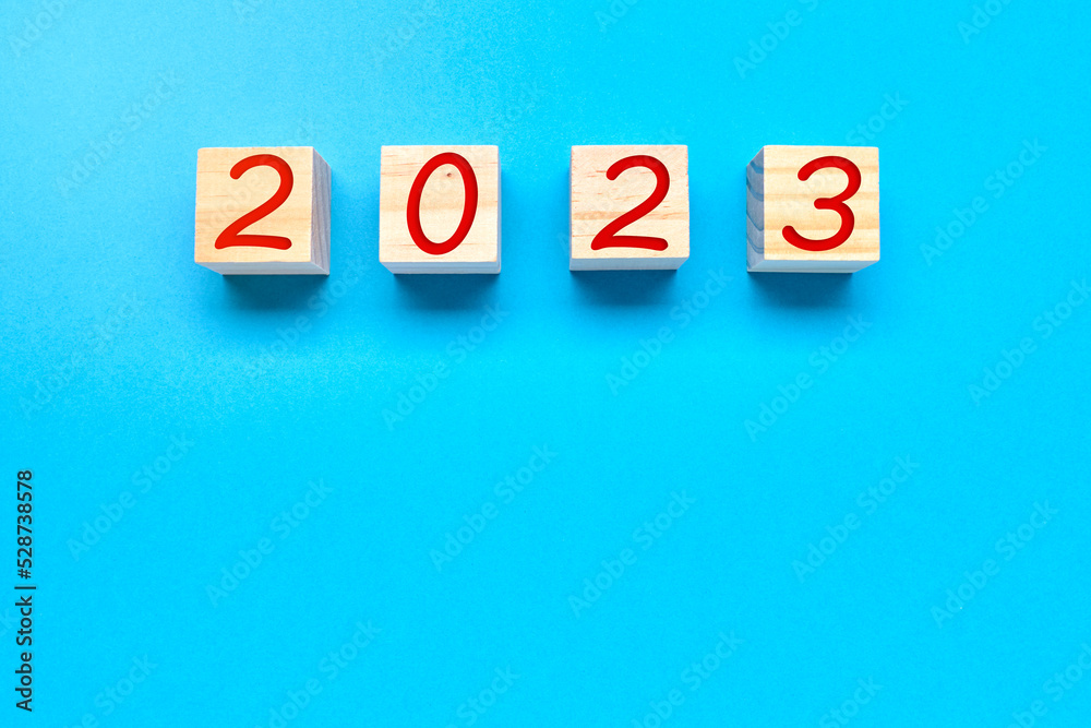 Wooden cubes with number 2023 on blue background. New Year Wooden cubes with number 2023 on blue background. New Year