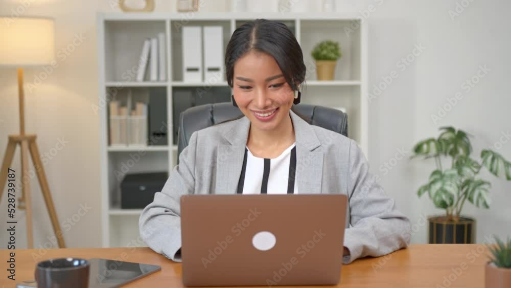 Asian businesswoman working on laptop in office. Successful Asian business woman working on computer while sitting at desk. Asian businesswoman working on laptop in office. Successful Asian business woman working on computer while sitting at desk.