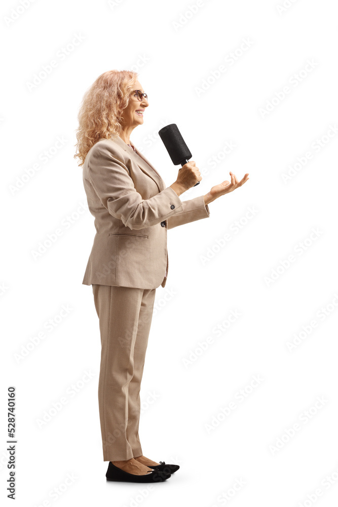 Full length profile shot of a female tv presenter with a microphone Full length profile shot of a female tv presenter with a microphone