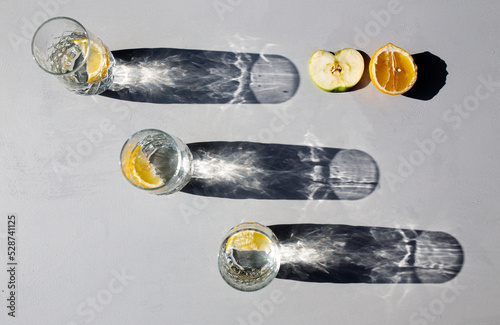 GLASS SHADOWS, BACKLIGHT REFLECTION, GLASSES AND LEMONS. photo