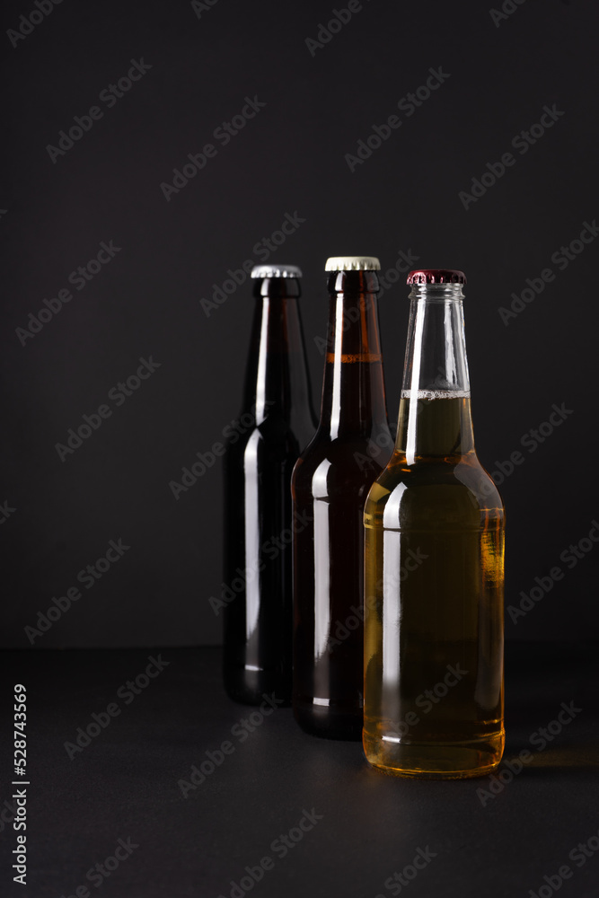 bottles with craft beer on a black background. Ale or lager from pilsner malt. homemade home-brewed beer. bottles with craft beer on a black background. Ale or lager from pilsner malt. homemade home-brewed beer.
