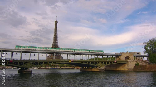 Iron bridge over the river in Paris near the metal tower on which the Paris metro passes. Metro train over Bir-Hakeim bridge and the Eiffel Tower photo